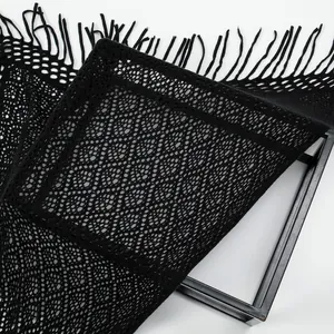 Detailansicht eines schwarzen Strickschals mit Fransen und filigraner Lochmuster-Textur