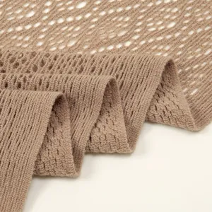 Detaillierte Nahaufnahme eines beigen, hohl gestrickten Schals mit eleganter Netzstruktur