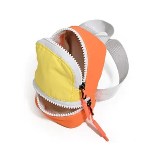 Close-up of vibrant yellow and orange mini backpack pouch with chunky white zippers