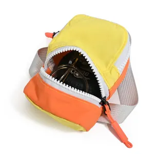Detail view of vibrant yellow and orange mini storage pouch with white zipper and glasses.