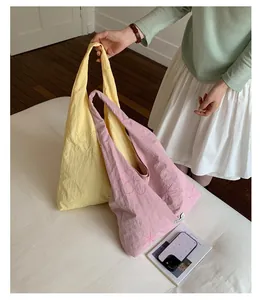 Close-up showing pink and yellow nylon tote bags with delicate floral embroidery details