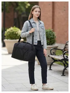 Photo de style de vie d'une fille portant un grand sac de voyage noir à l'épaule