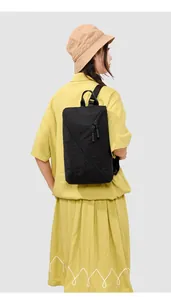 Sac à dos noir minimaliste en nylon porté par un mannequin pour le bureau et le sport