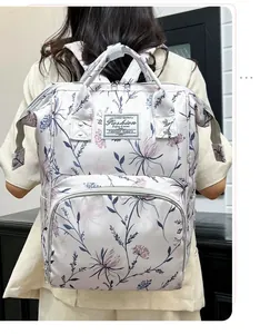 Dettaglio di uno zaino per neonati con stampa floreale indossato da una modella