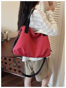 Large red checkered nylon tote bag shown in a lifestyle setting for daily commute