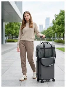 Grand sac de voyage gris et valise assortie présentés dans un cadre urbain extérieur.
