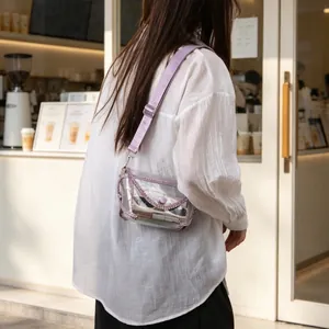 Stylish transparent PVC crossbody bag with purple rhinestone trim worn by model