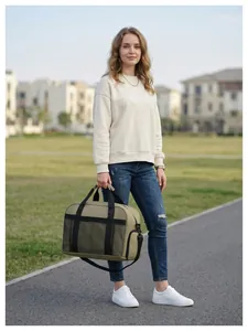Sac de voyage moderne vert olive de grande capacité tenu par une femme en extérieur