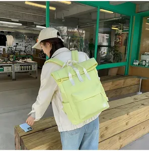 Detail view of the lime green minimalist travel backpack worn by a model in a trendy shop setting.