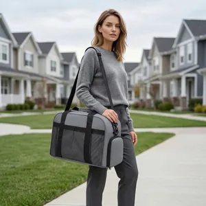 Grand sac de voyage gris porté par un mannequin dans une rue de banlieue