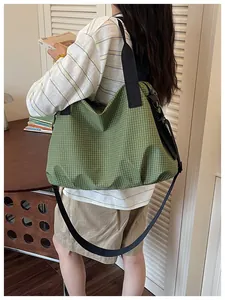 Large green checkered nylon tote bag shown from a side-back view on a model for commute.