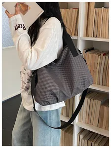 Asian model wearing a large checkered nylon tote bag in a cozy library setting