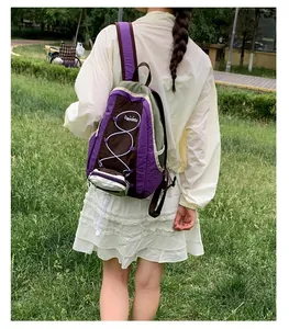 Vista trasera de una mochila de senderismo ligera de color púrpura usada en un parque.