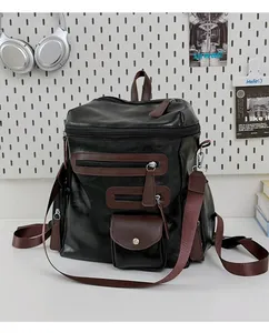 Retro black motorcycle backpack with brown trim and multiple zipper pockets on white desk.