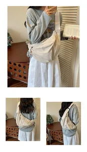 Dettaglio di una borsa a tracolla beige in nylon a forma di mezzaluna indossata da un modello.
