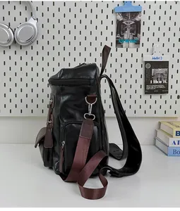 Side detail of a black vintage PU leather backpack with multiple zippers and brown straps