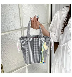 Bolso de mano a cuadros blanco y negro con lindo amuleto de oso y detalles de borla