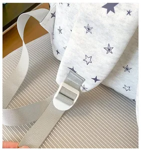 Detailed view showing the white buckle and grey strap of this star print backpack