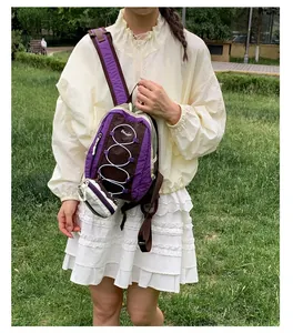 Mochila de senderismo ligera en color morado y marrón con cordones blancos al aire libre