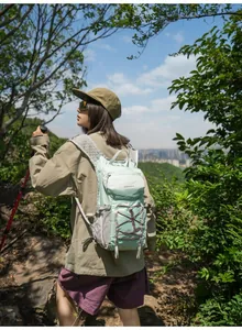 Detailed view of the lightweight mint green hiking backpack in an outdoor forest setting