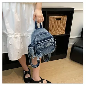 Stylish mini denim backpack with washed finish held by model in a cozy lifestyle setting