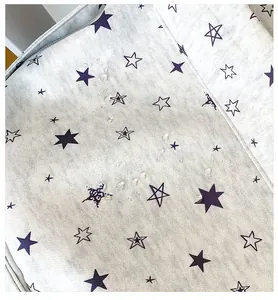 Close-up detail of star pattern fabric with water-repellent droplets on backpack
