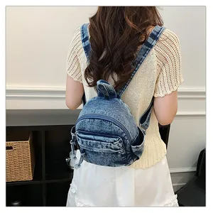 Back view of a casual washed denim mini backpack for women in a lifestyle setting