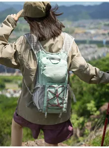 Back view of a lightweight mint green hiking backpack on a female hiker in nature