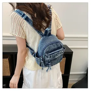 Back view of a woman wearing a blue washed denim backpack in a modern home setting.