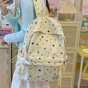 Detailed view of yellow backpack with star print pattern and adjustable straps