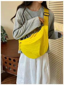 Borsa a tracolla in nylon giallo indossata da una modella in un contesto di vita casual
