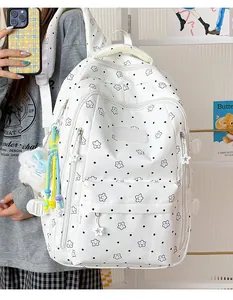 Nahaufnahme eines weißen Rucksacks mit Sternmuster und süßen Accessoires am Modell