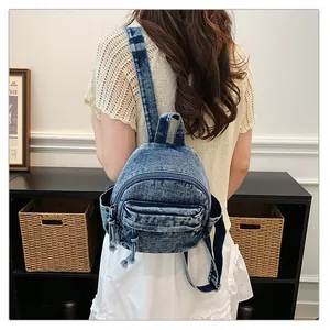 Washed denim backpack with multiple pockets shown from a back perspective on a model