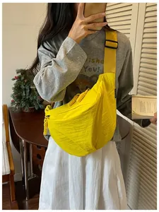 Borsa a tracolla in nylon giallo indossata da una modella in un ambiente casual