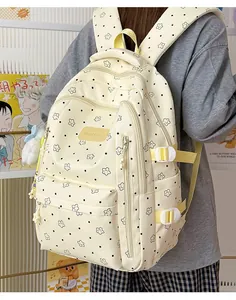 Detailansicht eines cremefarbenen Schülerrucksacks mit Sternenmuster und Tragegurten