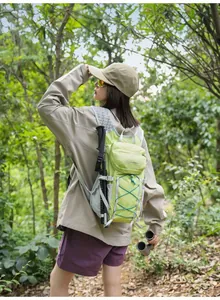 Lightweight lime green hiking backpack shown being worn in a natural forest outdoor setting