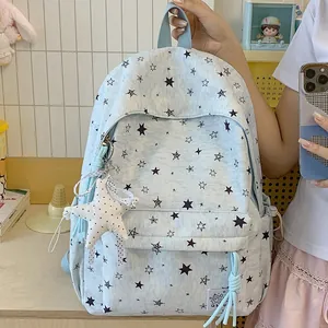 Detail view of light blue star print backpack featuring a cute plush star keychain