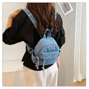 Rear view of a stylish light blue denim mini backpack for women in a casual setting