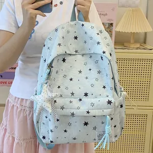 Close-up of a light blue star print backpack with a plush star pendant accessory.