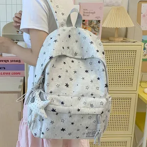 Close-up of gray backpack with black star print and plush star charm detail