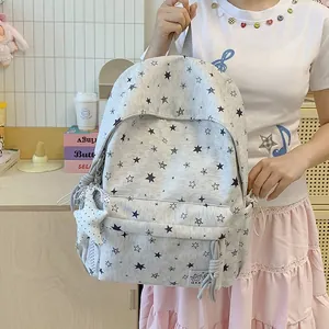 Close-up of star patterned backpack held by a girl in a casual indoor setting