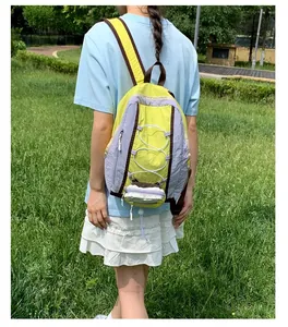 Vista trasera de una mochila ligera de senderismo amarillo neón usada por modelo afuera