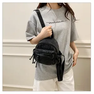 Detail view of a casual black denim backpack for women, student school bag style.