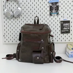 Vintage brown faux leather multi-zipper backpack on a white desk with creative props.