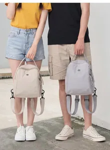 Mini zaini impermeabili nei colori beige e grigio per viaggi o pendolarismo giornaliero.
