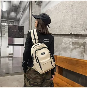 Detail view of a woman wearing the minimalist cream-white casual travel backpack outdoors