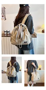 Dettaglio dello zaino con coulisse in nylon beige a grande capacità indossato