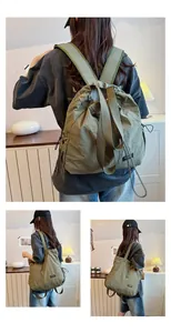 Modella indossa zaino in nylon impermeabile verde oliva per sport e pendolarismo