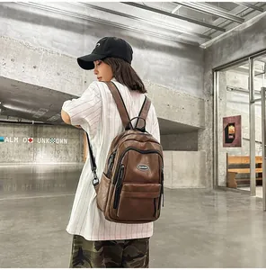 Close-up of a minimalist brown PU leather backpack worn by a model in an urban setting