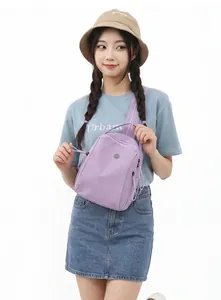 Dettaglio di un mini zaino viola impermeabile alla moda indossato da una modella